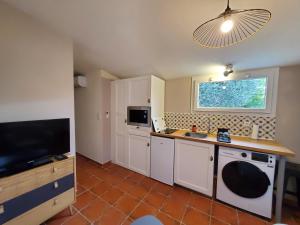 una pequeña cocina con fregadero y microondas en Le Bleu Mimosa, en Narbona