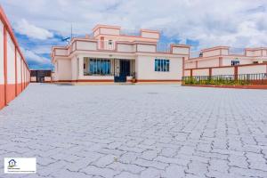 a large pink house with a large driveway at Taliah Homestays in Nanyuki