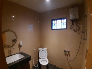 a bathroom with a toilet and a sink and a window at Orange Villa in Berastagi +22 photos