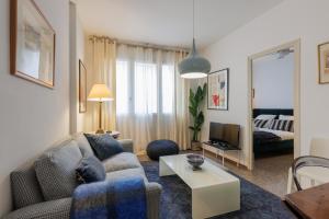 a living room with a couch and a table at Lodging Apartments Gracia 2 in Barcelona