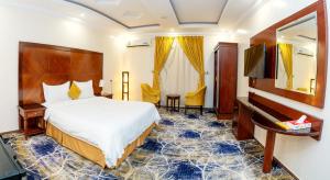 Habitación de hotel con cama y piano en فندق لمسات نجران en Najrán