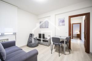 uma sala de estar com um sofá e uma mesa em Ático Quintana II - con terraza, en el centro con Wifi y garaje em Oviedo
