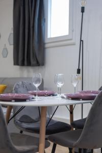 uma mesa com duas cadeiras e copos de vinho em Résidence Villette - Buttes Chaumont Botzaris em Paris