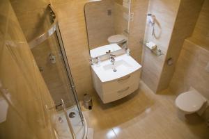 a bathroom with a sink and a shower and a toilet at Luxury Hotel Siófok in Siófok