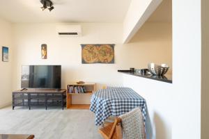 een woonkamer met een tafel en een televisie bij Fábrica da Ribeira 70 by Destination Algarve in Lagos