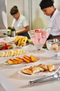 una mesa cubierta con platos de comida con fruta. en Peixe Crew Centro, en Búzios
