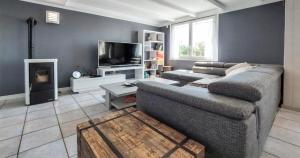 uma sala de estar com um sofá e uma televisão em Maison 4 personnes, Moëlan sur mer, proche plages em Moëlan-sur-Mer
