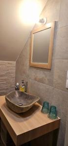 a bathroom with a stone sink and a mirror at Le Clos de la Belle Loge Location de studio 