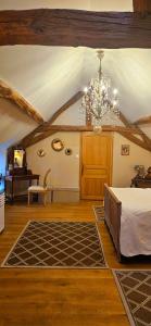 a bedroom with a bed and a chandelier at Le Clos de la Belle Loge Location de studio 