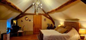 a bedroom with a large bed in an attic at Le Clos de la Belle Loge Location de studio 