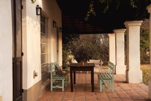 eine Veranda mit einem Tisch und 2 Stühlen auf einer Terrasse in der Unterkunft Finca Valentina in El Encón