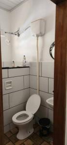 a bathroom with a white toilet and a sink at Sitio Cachoeira da Gomeira in Passa Quatro