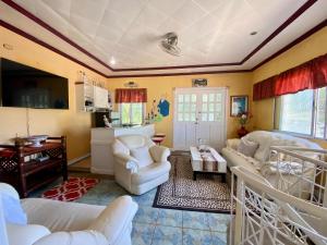 a living room with white furniture and yellow walls at La Casa Blanca Binoclutan in Botolan