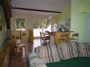 a living room with a couch and a kitchen at Gîte l'Ermitage Thiaucourt in Thiaucourt
