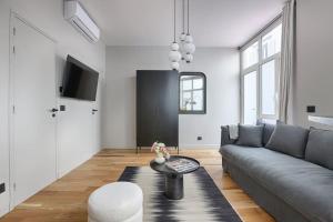 uma sala de estar com um sofá e uma mesa em MyKeypers - Luxury Studio 2P - Marais/Bastille em Paris