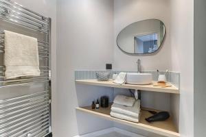 a bathroom with a sink and a mirror at MyKeypers - Luxury Studio 2P - Marais/Bastille in Paris