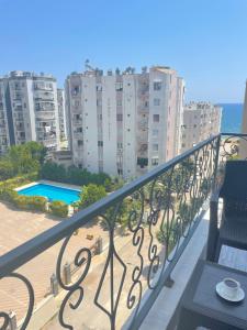 balcón con vistas a la playa y a los edificios en TEKER LUXURY HOTEL, en Mezitli