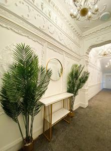 een kamer met een spiegel en een tafel met een plant bij Modern Studios Close To Hyde Park in Londen