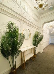a room with a mirror and a table with a plant at Modern Studios Close To Hyde Park in London