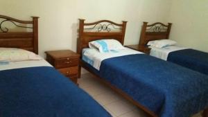 a bedroom with two beds with blue and white sheets at Residencial Teresita in Vallegrande