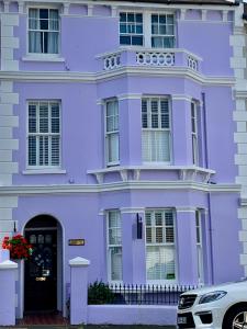 a purple house with a car parked in front of it at Gyves House in Eastbourne