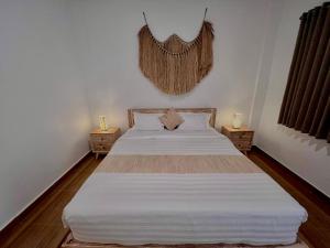 een slaapkamer met een groot bed met 2 nachtkastjes bij Nay's Homestay in Canggu