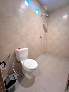 een badkamer met een wit toilet en een douche bij Nay's Homestay in Canggu