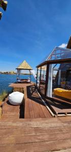 a wooden deck with a gazebo on the water at Glamping Titicaca Perú in Puno