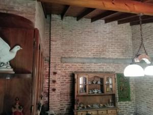 a living room with a brick wall and a shelf at Casa Redonda in Monte Grande