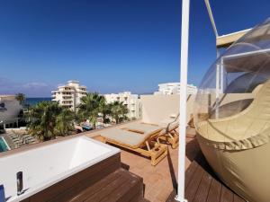einen Balkon mit einer Badewanne, einer Hängematte und Aussicht in der Unterkunft tent Capi Playa in Playa de Palma