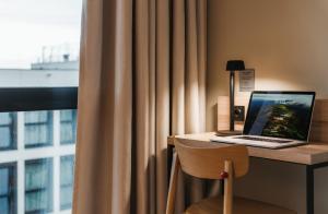 a laptop computer sitting on a desk next to a window at MEININGER Kraków Centrum in Kraków