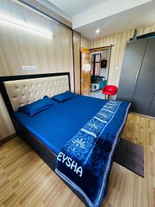 een slaapkamer met een bed met een blauw dekbed bij Dhauladhar Homes in Dharamshala
