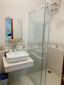 a bathroom with a sink and a glass shower at COZY Hotel HCM in Ho Chi Minh City +35 photos