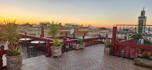 einen Balkon mit Tischen und Topfpflanzen auf einem Gebäude in der Unterkunft Riad Royal in Meknès