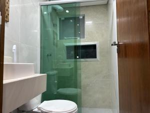 La salle de bains est pourvue d'une douche en verre et de toilettes. dans l'établissement Moradas Desterro, próximo ao aeroporto 02, à Florianópolis