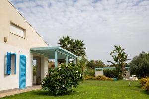 a house with a blue door and a yard at Villa Dafne in Villaggio Azzurro