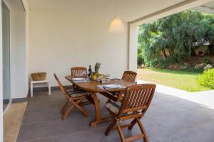 a dining room with a wooden table and chairs at Villa Dafne in Villaggio Azzurro