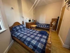 a small bedroom with a bed and a microwave at Abbey Guest House in Milton Keynes