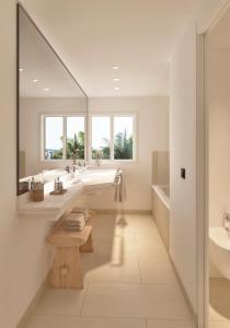 a bathroom with two sinks and a tub and a mirror at Meliá Lloret de Mar in Lloret de Mar