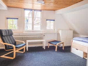 um quarto com uma cama e uma cadeira em Küsterhaus Gräfrath em Solingen