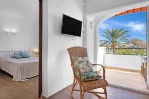 a room with a chair and a balcony with a bed at Albatros 2 in Denia