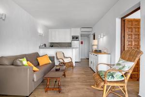 a living room with a couch and chairs and a kitchen at Albatros 2 in Denia