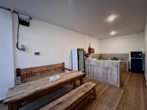 een keuken met een houten bank en een koelkast bij Nay's Homestay in Canggu