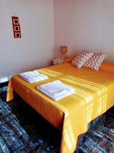 1 dormitorio con 1 cama con manta amarilla en Departamento Ámbar en Godoy Cruz en Godoy Cruz