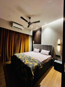 - une chambre avec un lit et un ventilateur de plafond dans l'établissement Luxe Apartment by Hey Studio's, à Ghaziabad