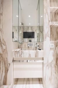 biała łazienka z umywalką i lustrem w obiekcie Chiado Camões Apartments | Lisbon Best Apartments w Lizbonie +42 zdjęcia