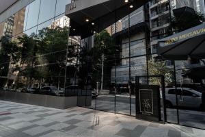 a glass building with a sign in front of it at Yume Vitrali Studios in Sao Paulo