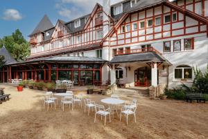 un grand bâtiment avec des tables et des chaises devant lui dans l'établissement Hôtel Miléade Les Pléïades La Baule, à La Baule