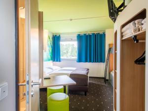 una camera d'albergo con letto e tavolo di B&B Hotel Erlangen a Erlangen