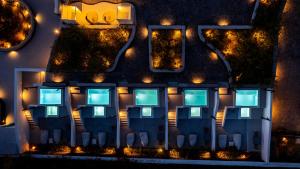 a building with chairs in front of it at night at Santa Irina Luxury Sunny Lofts in Perivolos +37 photos